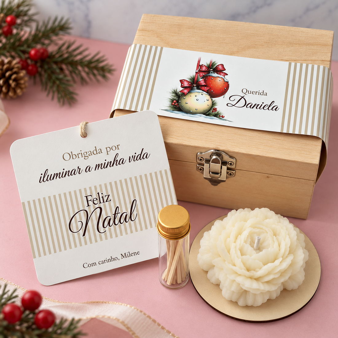 White flower-shaped candle, small bottle and Christmas card beside a personalised wooden box