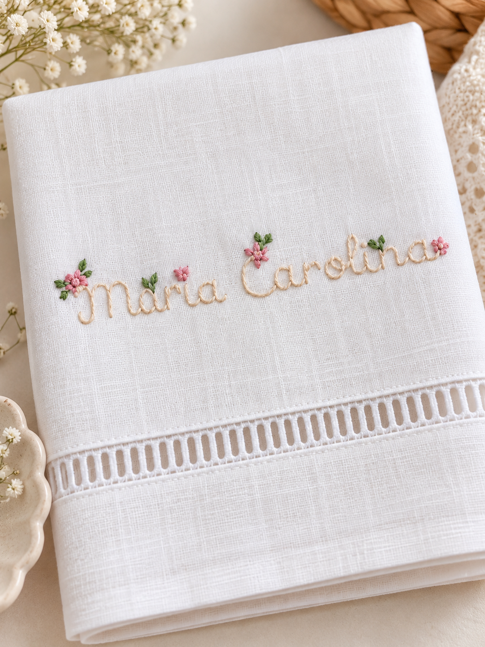 White baptism towel with a personalised name, embroidered pink flowers and an openwork hem